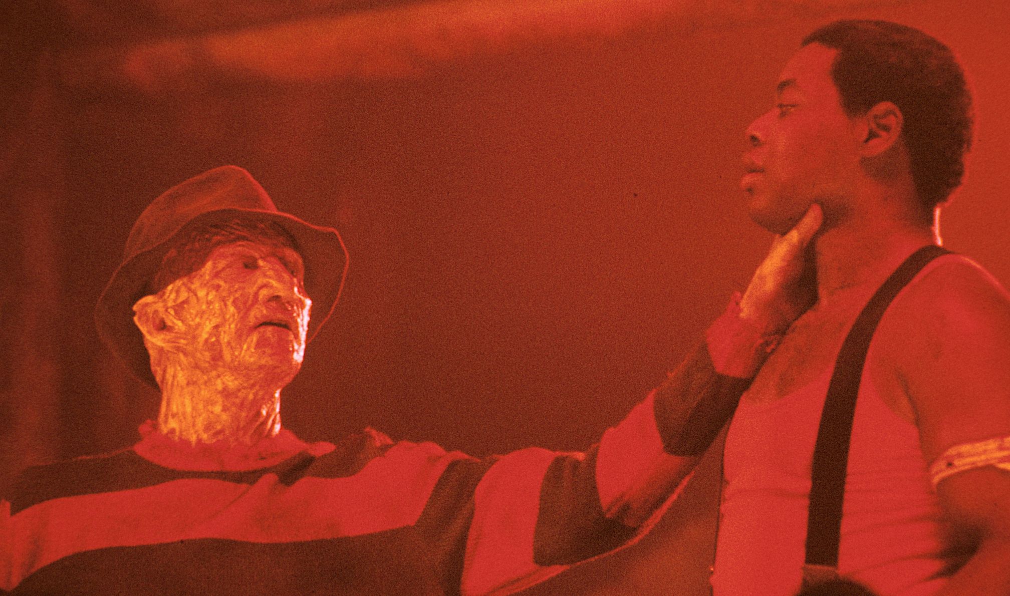 O vilão do Nightmare on Elm Street Series, Freddy Krueger, mantém uma vítima pela garganta.